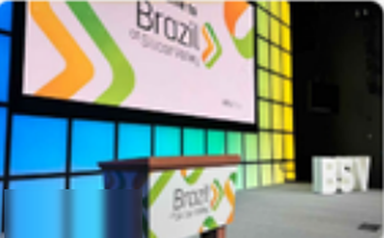 Palco do Brazil at Silicon Valley com painel colorido e púlpito com a marca do evento.