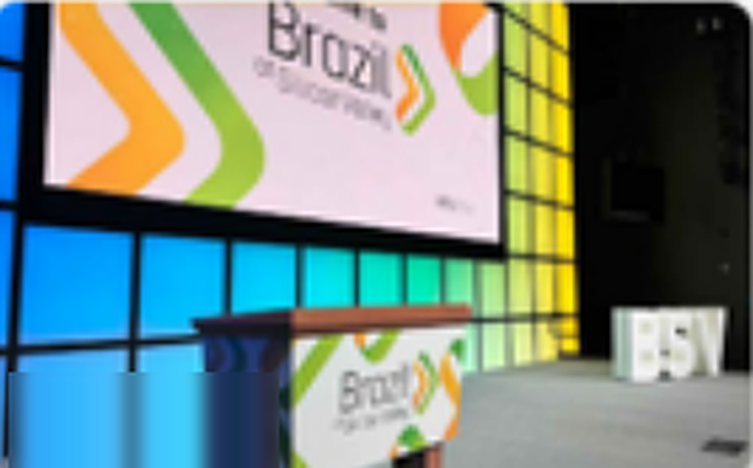 Palco do Brazil at Silicon Valley com painel colorido e púlpito com a marca do evento.