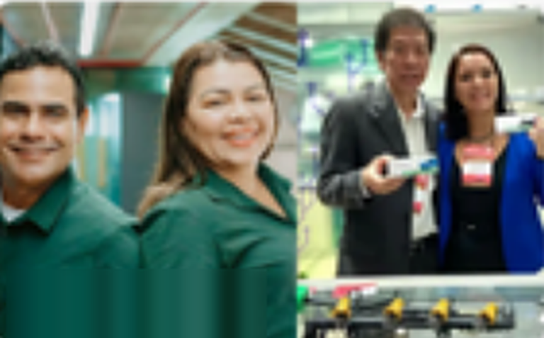 Duas pessoas sorridentes de uniforme verde e, ao fundo, outras duas segurando um dispositivo.